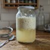 Bocal de kéfir de lait séparé en caillé et petit-lait sur un plan de travail